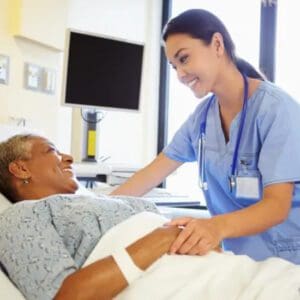 A nurse is smiling at an older patient in the hospital.