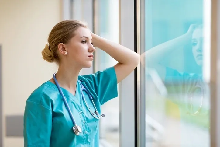 A female nurse looking out of the window