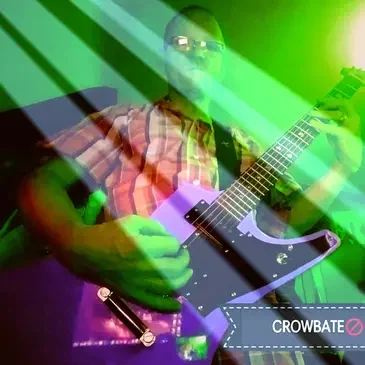 A person playing an electric guitar in front of green lights.