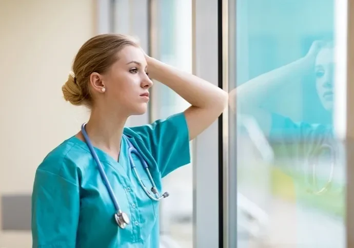 A female nurse looking out of the window